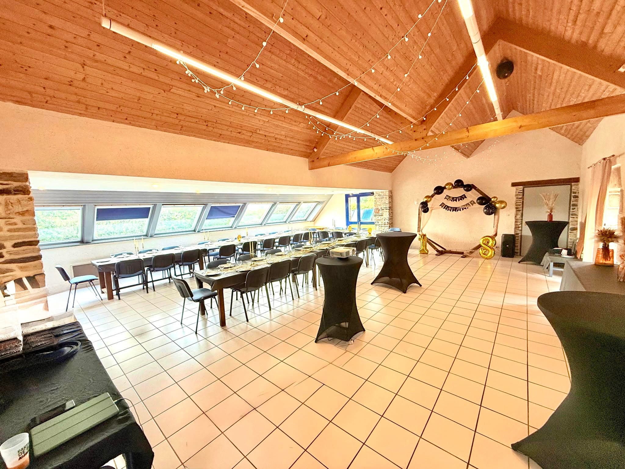Grande salle de réception lumineuse avec charpente bois